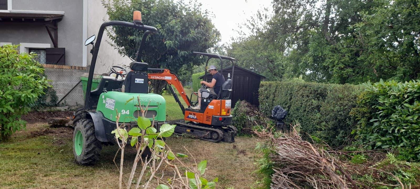 Mini-pelle en action pour le nettoyage et le terrassement d'un jardin dans l'Aube.